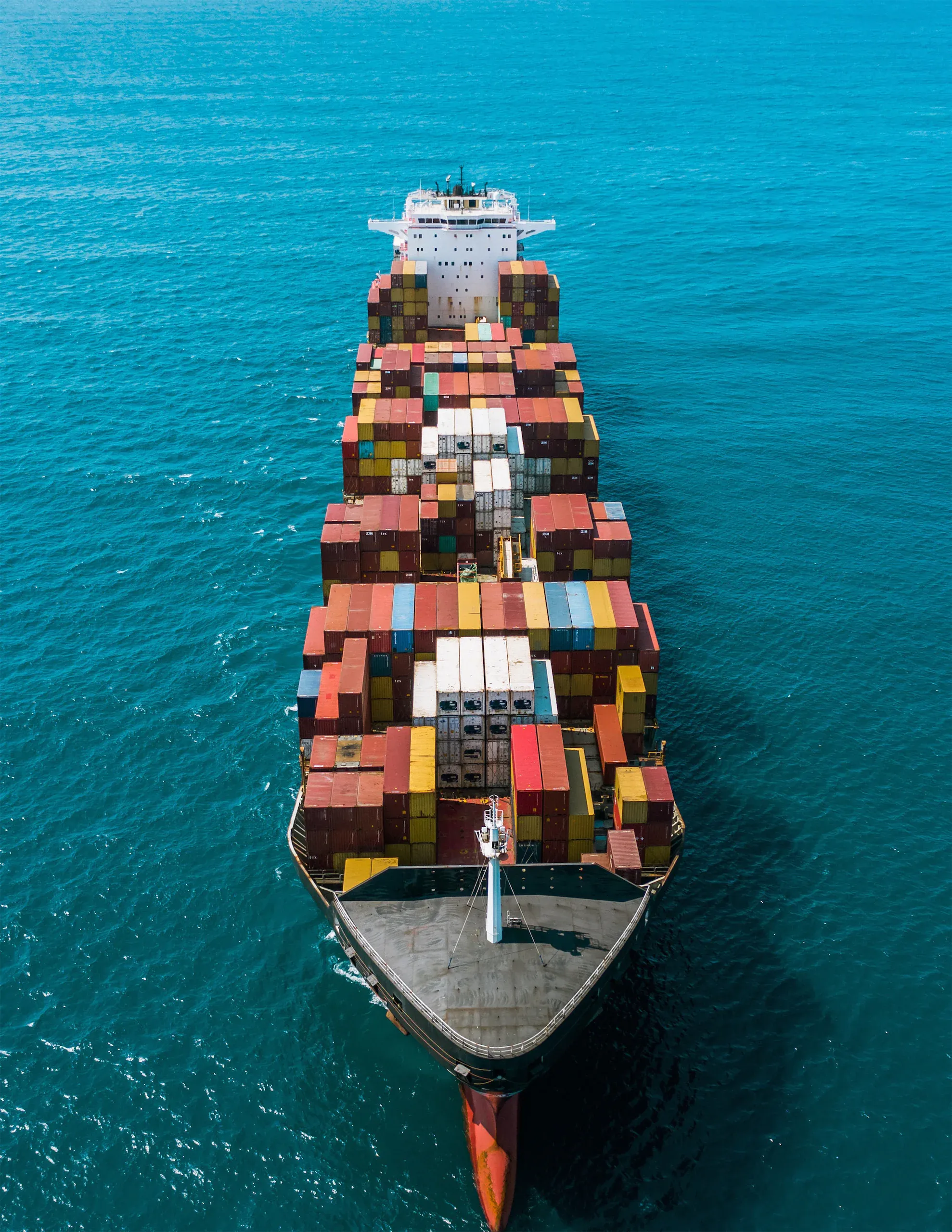An aerial drone shot of a cargo ship facing head-on